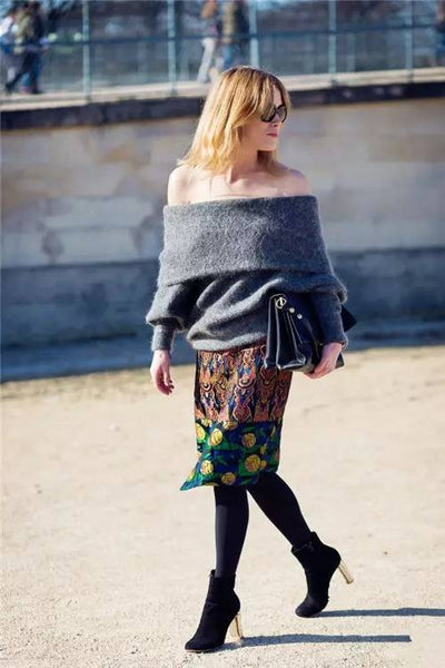 Off-the-shoulder knitted sweater + printed skirt + short boots + clutch